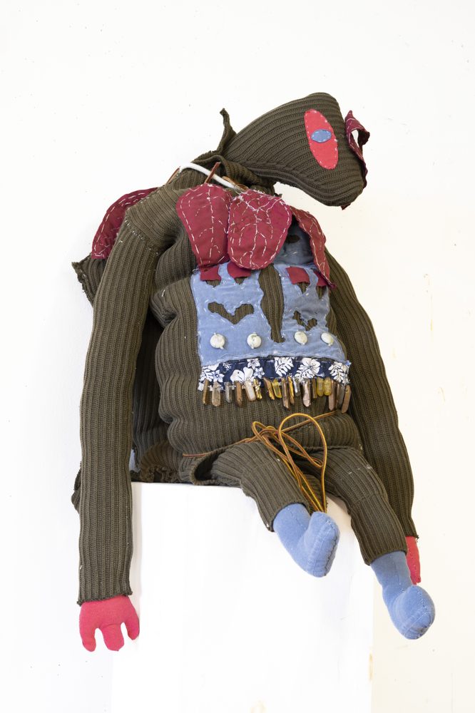 Hand-stitched soft sculpture: Joe the Turtle, on a white pedestal.
